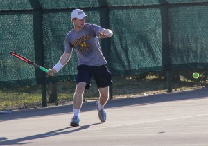 Senior Tyler Jeffers goes for an underhand shot against Bethel University at the Bennie Purcell Courts Tuesday. Despite starting the season 0-9, the team still confident they can earn a win in conference play. || Lori Allen/The News