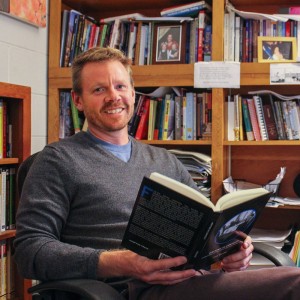 Kate Russell/The News Paul Walker, associate professor of English, sits in his office with his recently published book, “Writing in Context: Composition in First-Year Learning Communities.”  