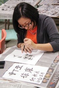 Lori Allen/The News Esther Chen, international graduate student from Malaysia, practices writing the Bible verse John 3:16 in Chinese characters at a calligraphy workshop held during International Education Week