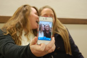 Lexi Sosh, junior from Evansville, Ind., and Taylor Strohmeier, junior from Louisville, Ky., take a Snapchat photo with a smartphone. || Anna Taylor/The News 