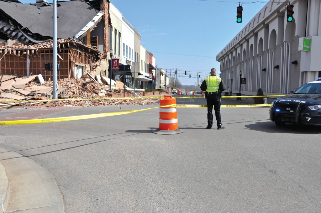 Ana Bundy/The News A police officer stands near the site of Saturday’s building collapse.