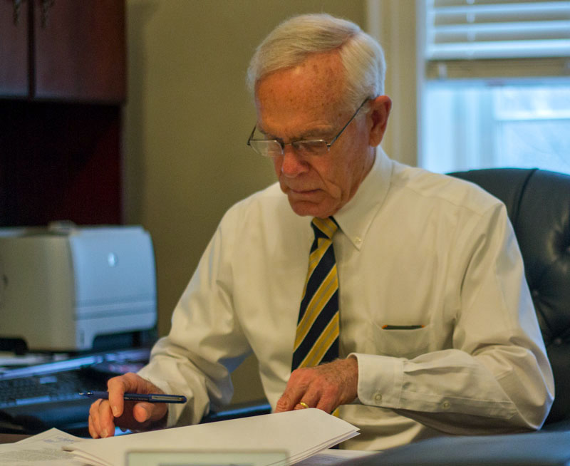 Lori Allen/The News Interim President Tim Miller sits in his office in Wells Hall looking over paperwork. Miller, who has one month left in the president’s seat, has been with the University for more than 40 years as a student, professor and president.