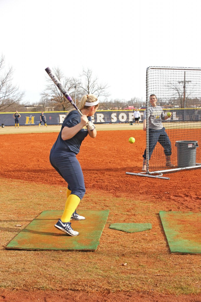 Kate Russell/The News Freshman Taylor Odom takes batting practice from Head Coach Kara Amundson. 