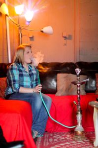 Jenny Rohl/The News Elisha Cherry, employee of The Breakaway Lounge, smokes hookah. 