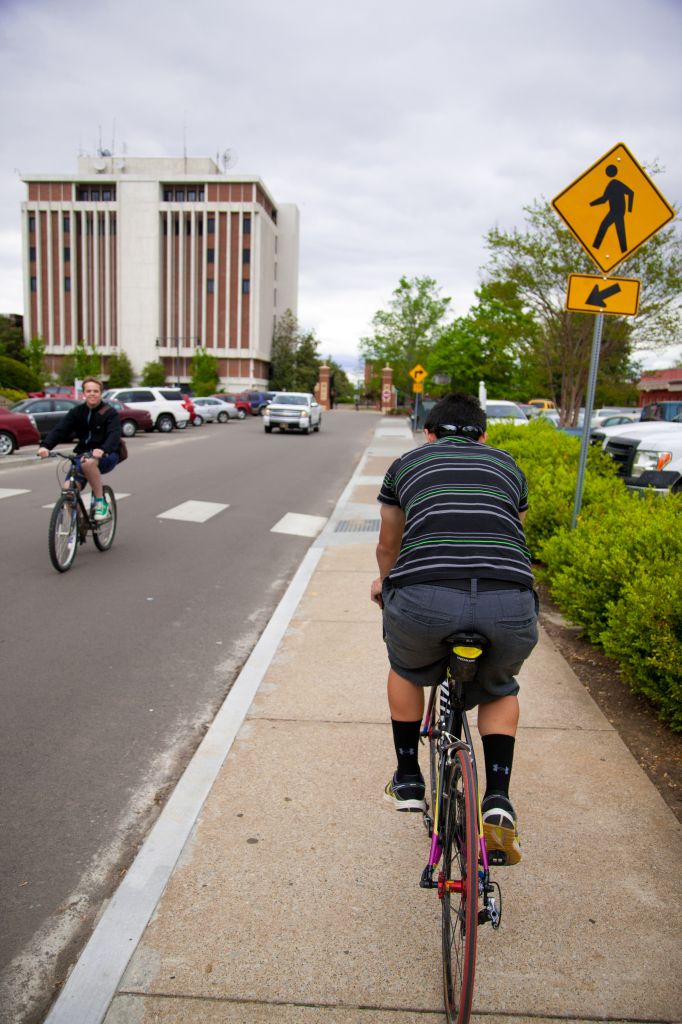 Haley Hayes/Contributing photographer Bikers use the sidewalk and street to navigate around campus.