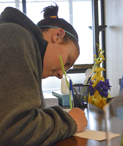 Hannah Fowl/The News Maci Dungan, sophomore from Miamisburg, Ohio, fills out forms for financial aid. 