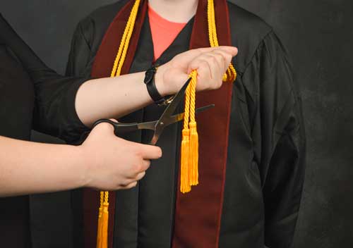 Photo Illustration by Hannah Fowl/The News Gold cords are given to students who achieve honors such as cum laude with their graduation robes.