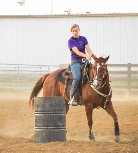 Emily Harris/The News Ellen Adams from McDonough, Georgia practices barrel racing for an upcoming college rodeo in Marshall, Missouri.