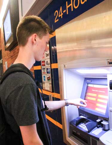 Jenny Rohl/The News Kristian Hoybye, freshman from Denmark, uses an ATM in the Curris Center.