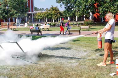 McKenna Dosier /The News Leah Krause, graduate student from St. Charles, Missouri, learned how to properly use a fire extinguisher during Campus Fire Safety Day Thursday afternoon. 