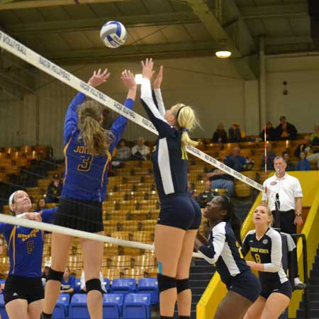 Chalice Keith/The News Emily Schmahl, senior outside hitter, jumps the net and blocks the ball.