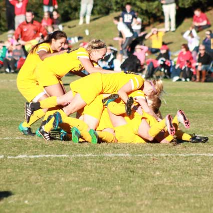 Jenny Rohl/The News The Racers pile up in celebration after scoring the game-winning goal in overtime to earn their second OVC Tournament title.