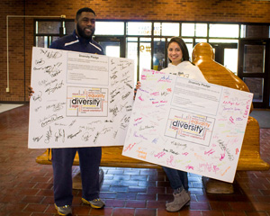 Savana Smothers/The News Two students hold the Diversity Pledge boards in the Curris Center. The pledge has received half of the 5,000 signature goal. 