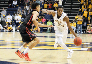 Nicole Ely/The News Moss dribbles past defender during his senior year, in which he contributed 14.2 points per game. He helped lead the Racers to get their 29th consecutive winning season. 